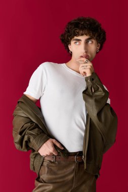 Şık bir adam, vurucu bir zemine karşı düşünceli bir şekilde poz verir..