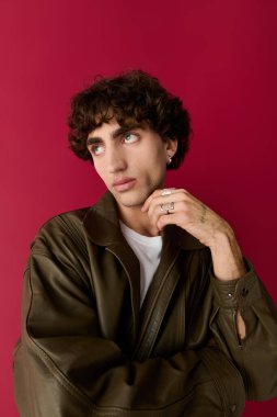 Moda giyinmiş yakışıklı bir adam zarif bir şekilde kendine güvenen bir pozla kendini ifade eder..