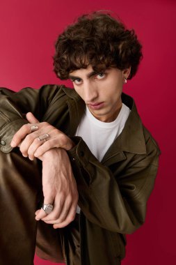 Şık giyimli bir adam, eşsiz stili ve özgüveni ile canlı bir arkaplan önünde caka satar..