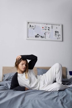 Genç bir kadın gününü yatakta yalnız geçirir, rahat dairesinde dinlenerek..