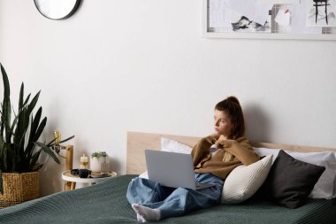 Genç bir kadın gününü yatakta uzanıp, rahat bir dairedeki hayatı düşünerek geçirir..