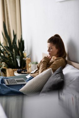 Genç bir kadın rahat bir şekilde yatağında dinleniyor, rahat bir şekilde giyiniyor ve günün tadını çıkarıyor..