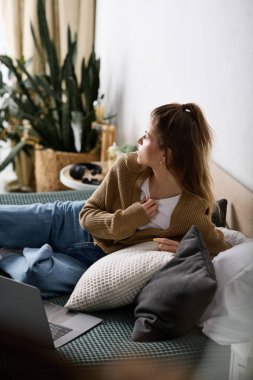 Genç bir kadın boş zamanlarında şık bir dairede tek başına dinleniyor..