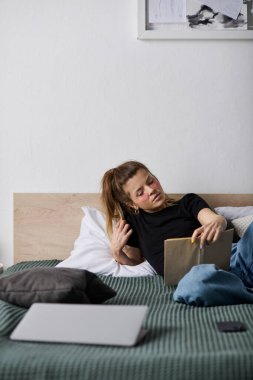 Genç bir kadın günlerini yatakta rahat geçirir, rahat giyinip, yalnız başına vakit geçirir..