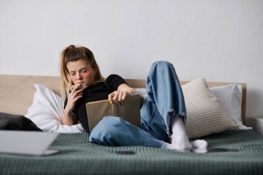 Genç bir kadın, tembel bir günün tadını çıkarır. Yatakta yalnız, odaklanmış ve rahat dairesinde..