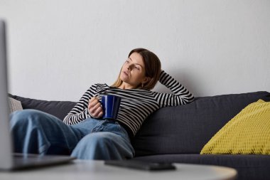 Genç bir kadın vaktini dinlenerek ve içki içerek geçirir, yalnız başına dinlenir..