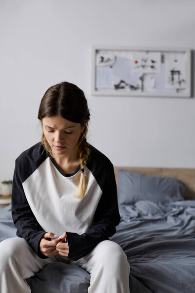A young woman spends her day in bed, embracing moments of solitude.