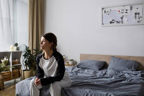 A young woman spends a quiet day in bed, reflecting on life in her cozy apartment.
