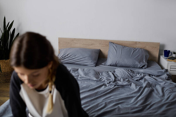 A young woman enjoys a leisurely day in her modern bedroom, taking time to relax and recharge.