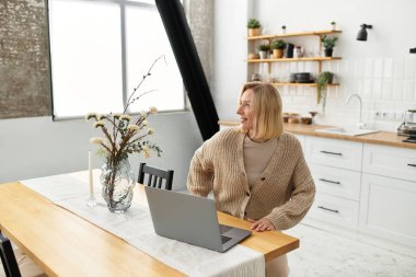 Sarışın kadın rahat giysiler içinde, modern dairesinin huzurunun tadını çıkarıyor..