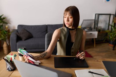 Genç kadın, bitkiler ve sanat malzemeleriyle çevrili yaratıcı projelerine odaklanıyor..