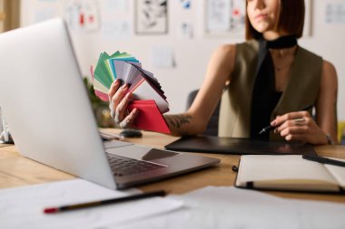 Yaratıcı kadın yeni projesini tasarlarken canlı renk örneklerini gözden geçiriyor..