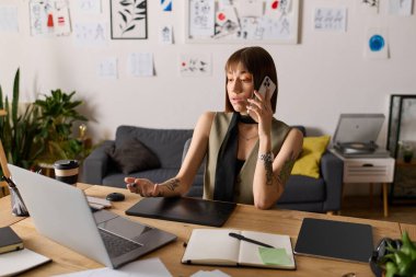 Evde sanat ve tasarım araçlarıyla çevrili genç bir kadın telefonla konuşuyor..