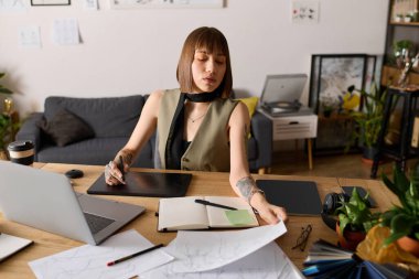 Genç bir kadın ev masasında tasarım işine odaklanmış, etrafı bitkiler ve sanat malzemeleriyle çevrili..