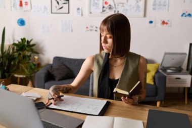 Genç, yaratıcı bir kadın evdeki bir defterden bahsederken çizim yapıyor..