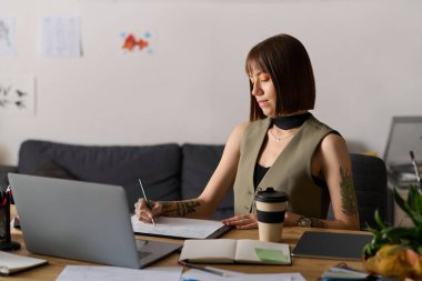 Genç bir kadın evde yaratıcılığını ifade ediyor, fikir çiziyor ve gün içinde kahveden zevk alıyor..