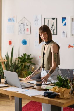 Genç ressam, bitkiler ve sanat eserleriyle çevrili yaratıcı projeleriyle evde meşgul oluyor..