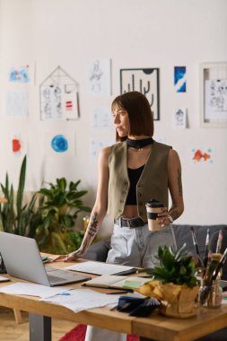 Genç bir kadın evinde kahvesini yudumluyor, tasarım projelerine odaklanıyor..