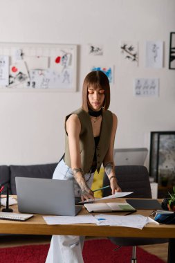 Genç bir kadın evde sanatsal projelere odaklanırken yaratıcı çalışma alanını düzenliyor..