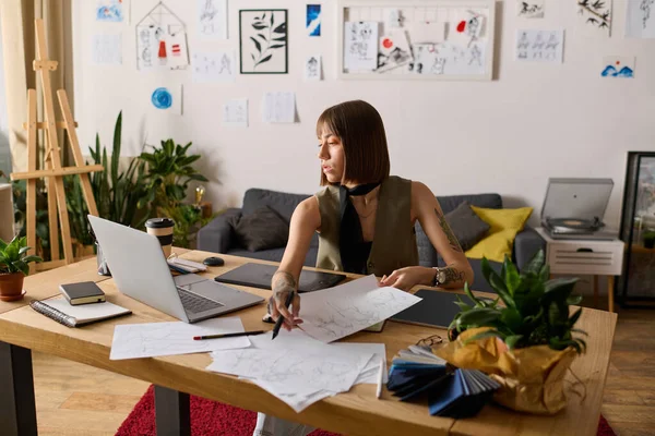 Genç ressam, çizimler ve bitkilerle çevrili yaratıcı projelerine odaklanmış durumda..