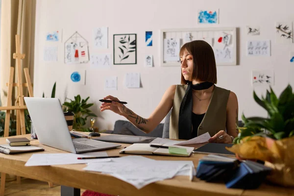 Genç bir kadın evde sanatsal projeler yapıyor, tasarımlar yaratıyor ve fikirleri keşfediyor..