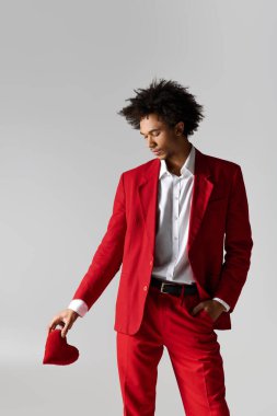 Şık kırmızı elbiseli genç adam zarif bir kalp taşıyor, zarafet saçıyor..