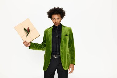 Zarif kıyafetli kendine güvenen genç adam güzel bir hediyeyle gülümsüyor..