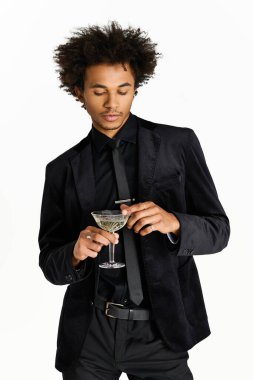 Şık siyah elbiseli genç bir adam şık bir toplantıda kokteyl içmekten hoşlanır..