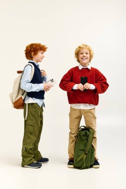 İki erkek birlikte eğlenirken şık kıyafetlerini ve gülümsemelerini sergiliyorlar..