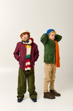 İki çocuk yan yana şık kıyafetler içinde, canlı renkler ve oyuncu stiller sergiliyor..