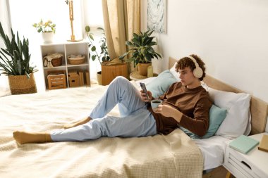 Kıvırcık saçlı ergen, şık yatak odasında, müziğe dalmış bir şekilde rahat bir zaman geçiriyor..