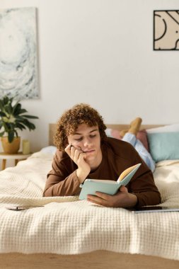 Genç bir çocuk şık dairesinde kitap okurken yatağında dinleniyor..