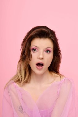 Pembe makyajlı genç ve güzel bir kadın saf bir organza bluz giyerken sürpriz yapıyor..