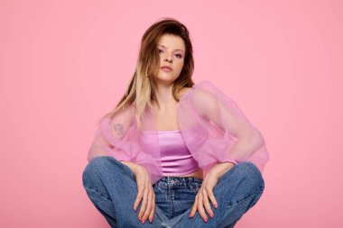 Genç bir kadın özgüvenle poz veriyor. Pembe makyajlı saf bir organza bluz. Modern güzelliğin vücut bulmuş hali..