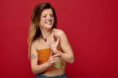 Genç kadın canlı bir stüdyo ortamında ışıl ışıl makyaj ve moda sergiliyor..