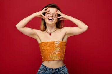 Parlak makyajlı genç bir kadın modaya uygun bir stüdyoda zevkle poz veriyor..