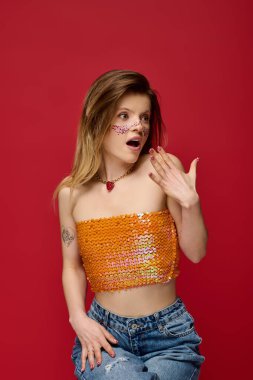 Çekici genç bir kadın, şık bir stüdyo arkaplanında parlak makyajını sergiliyor..