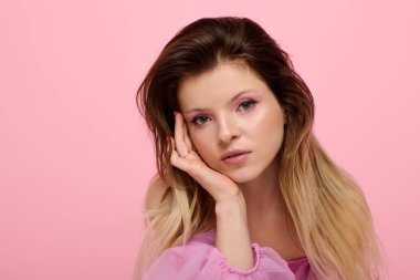 Güzel genç bir kadın pembe göz makyajı modelleri ve canlı bir stüdyoda saf bir organza bluz..