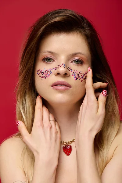 Çekici genç kadın, yaratıcı makyajını ışıl ışıl detaylarla, zarifçe poz vererek sergiliyor..