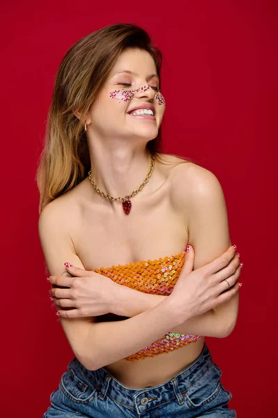 Genç bir kadın parlak makyajla gülümseyen canlı bakışlarını stüdyoda sergiliyor..