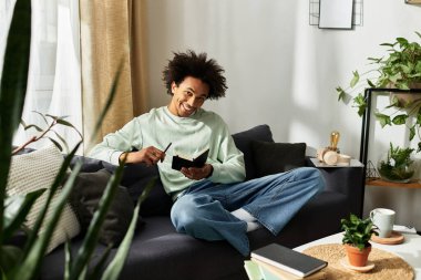 Yakışıklı genç adam evdeki not defterine yazarken kanepede dinleniyor..