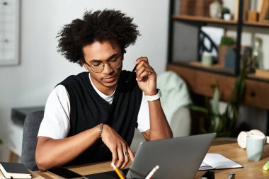 Yakışıklı bir genç adam, rahat, modern bir ev ofisteki görevlerine odaklanmış, yaratıcılığı kucaklıyor..