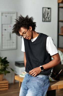 Genç bir Afrikalı Amerikalı adam rahat modern evinde rahatlıyor ve sıcak bir hava yaratıyor..