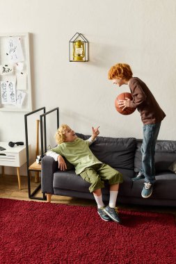 İki neşeli çocuk şık evlerinde basketbol oynarken kahkahalarını paylaşıyor..