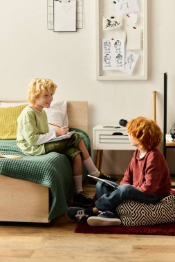 İki mutlu çocuk evde eğlenceli bir anı paylaşıyor, şık odalarında resim çizip gülüyorlar..