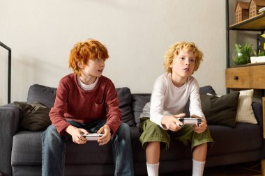 İki çocuk modern bir yaşam alanında, konsollarında oyun oynamaktan zevk alıyor, eğleniyorlar..