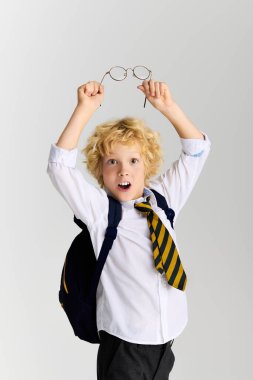 Okul üniformalı neşeli çocuk coşkuyla kadehleri kaldırıyor, bir anlık heyecan gösteriyor..