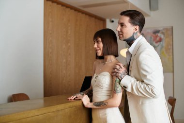 Otel resepsiyonundaki genç bir çift zarif kıyafetleriyle sevgi ve neşe yayıyor..