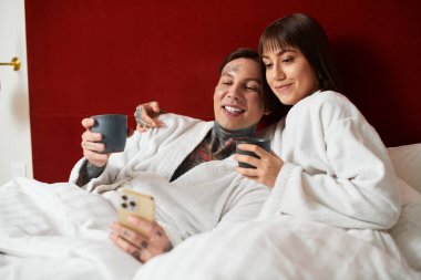 Sevgi dolu bir çift yatakta kıvrılır, gülücükler ve içkileri paylaşır, birlikte güzel anılar yaratırlar..