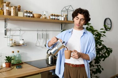 Rahat bir dairede, genç bir adam rahatlarken gülümseyerek kahve hazırlar..